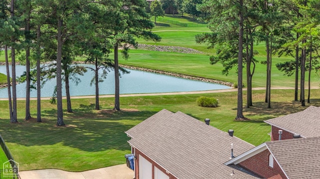 view of property's community with a water view, a yard, and golf course view