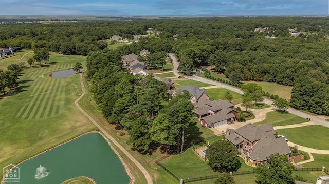 view of property location featuring a large body of water, a heavily wooded area, and a golf club