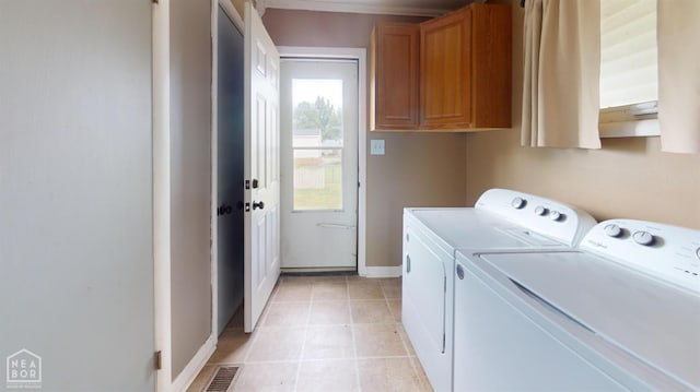 207 11th St, Marked Tree, AR 72365 - laundry area featuring washing machine and clothes dryer, cabinet space, and light tile patterned floors