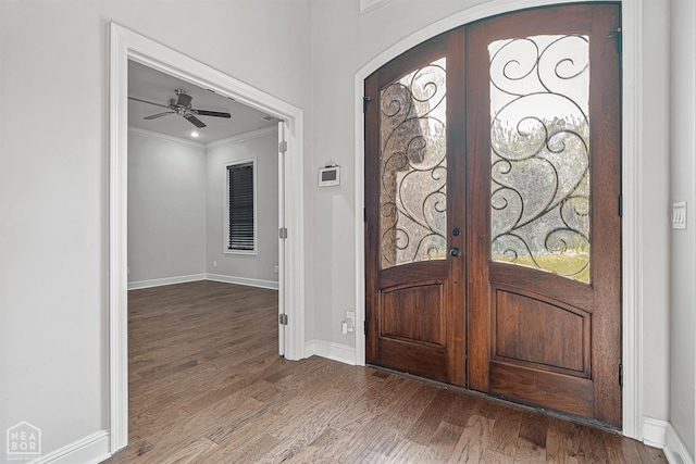 entrance foyer with french doors, baseboards, ornamental molding, and wood finished floors