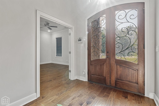 entryway with french doors, baseboards, crown molding, and wood finished floors