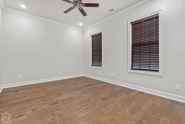 spare room with ornamental molding, visible vents, a ceiling fan, and dark wood-style floors