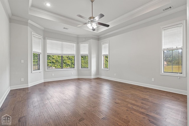 spare room with visible vents, ceiling fan, dark wood finished floors, crown molding, and a tray ceiling