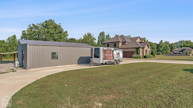 exterior space with metal roof, driveway, and a front lawn