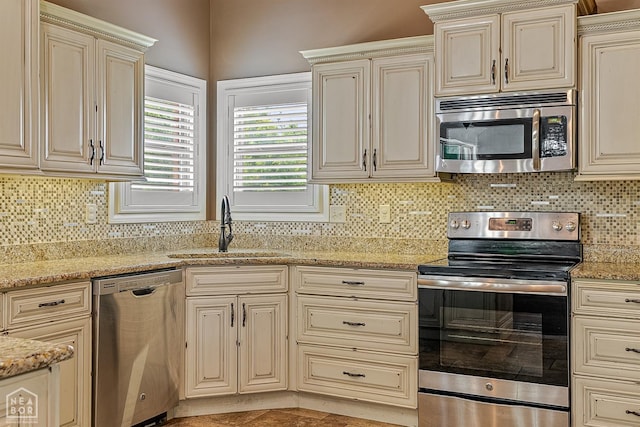 719 Smithfield Dr, Jonesboro, AR 72401 - kitchen with stainless steel appliances, cream cabinetry, a sink, and tasteful backsplash