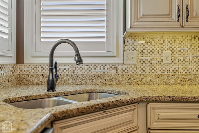 719 Smithfield Dr, Jonesboro, AR 72401 - kitchen view of a sink, decorative backsplash, light stone countertops, and cream cabinets