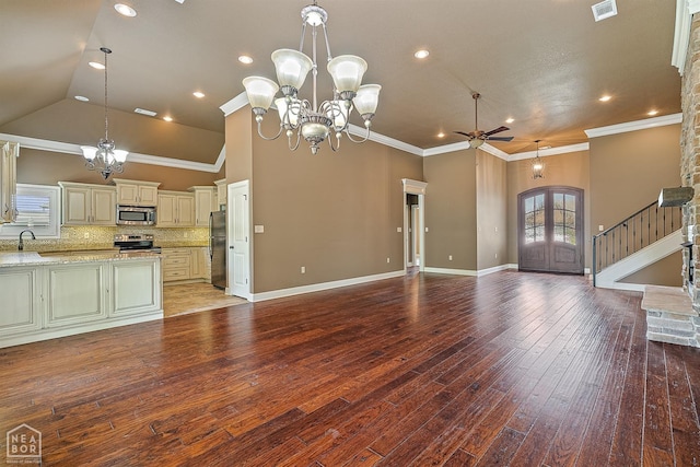 719 Smithfield Dr, Jonesboro, AR 72401 - unfurnished living room with a chandelier, a ceiling fan, a sink, stairs, and vaulted ceiling