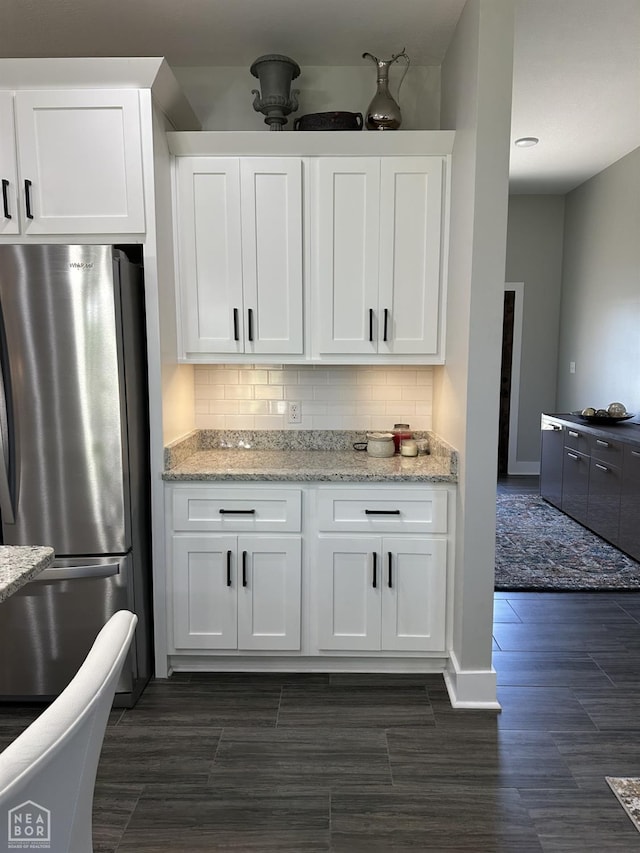 105 Brayden Ln, Brookland, AR 72417 - kitchen with freestanding refrigerator, white cabinets, backsplash, wood finish floors, and light stone countertops