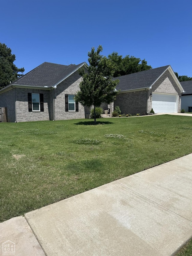 105 Brayden Ln, Brookland, AR 72417 - ranch-style house featuring a garage, a front lawn, brick siding, and a shingled roof
