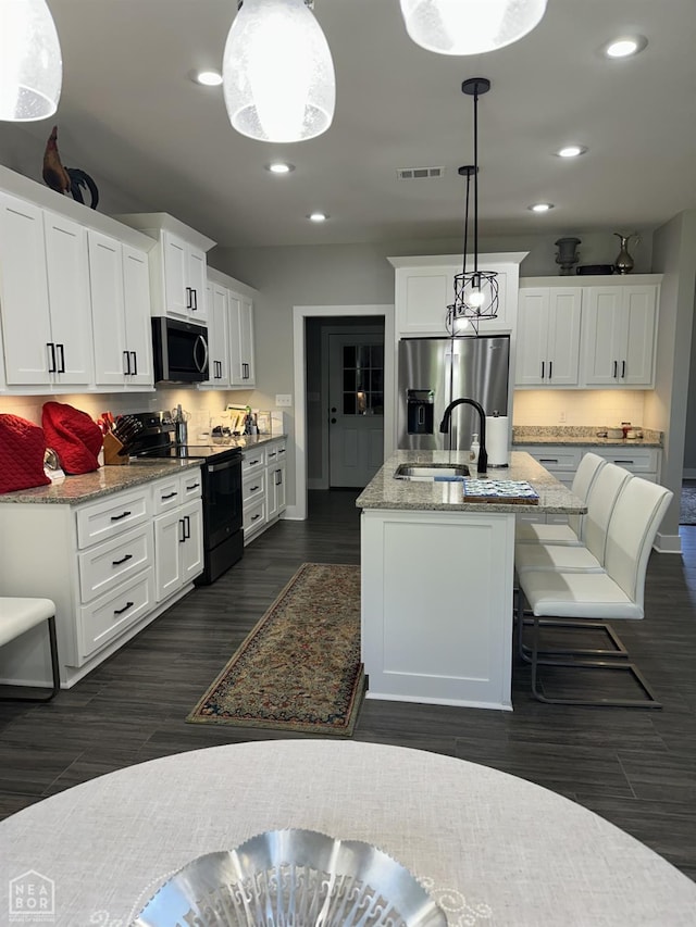 105 Brayden Ln, Brookland, AR 72417 - kitchen featuring stainless steel appliances, recessed lighting, dark wood finished floors, light stone counters, and white cabinetry