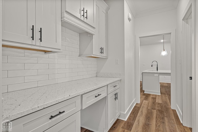 3425 Hudson Ct, Jonesboro, AR 72405 - kitchen with dark wood-type flooring, tasteful backsplash, crown molding, light stone counters, and white cabinetry