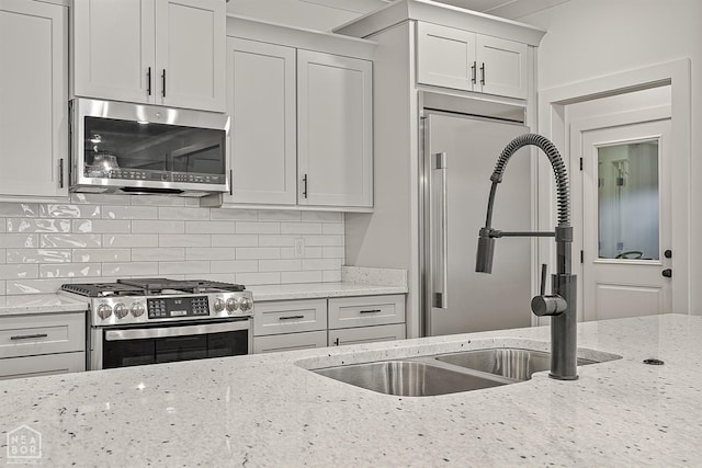 3425 Hudson Ct, Jonesboro, AR 72405 - kitchen with stainless steel appliances, decorative backsplash, light stone countertops, a sink, and white cabinetry