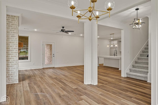 3425 Hudson Ct, Jonesboro, AR 72405 - unfurnished living room with stairs, light wood-type flooring, baseboards, a chandelier, and a sink