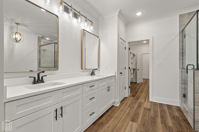 3425 Hudson Ct, Jonesboro, AR 72405 - bathroom with a shower stall, double vanity, ornamental molding, wood finished floors, and a chandelier