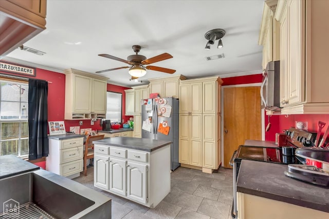 316 SE 2nd St SE, Walnut Ridge, AR 72476 - kitchen featuring stainless steel appliances, cream cabinetry, dark countertops, and a ceiling fan