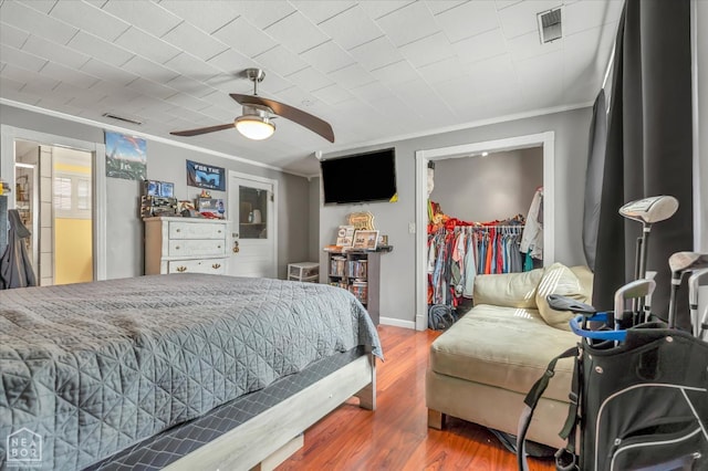 316 SE 2nd St SE, Walnut Ridge, AR 72476 - bedroom featuring crown molding, wood finished floors, a walk in closet, and ceiling fan