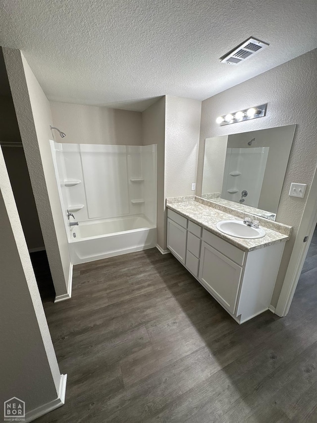 3726 Glitterman Dr, Jonesboro, AR 72404 - full bath with vanity, a textured wall, wood finished floors, a textured ceiling, and shower / tub combination