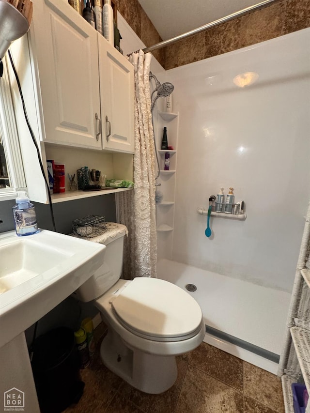 full bath featuring toilet and a shower stall