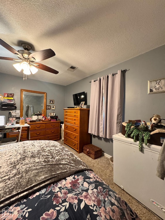 carpeted bedroom with a ceiling fan, a textured ceiling, and visible vents