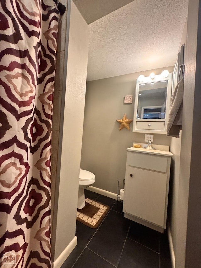 full bathroom featuring vanity, toilet, a shower with shower curtain, a textured ceiling, and tile patterned floors