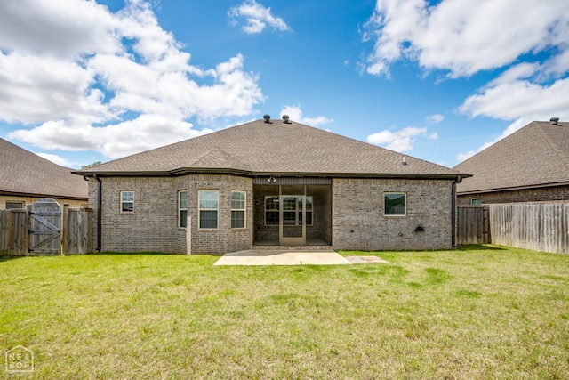 rear view of property with brick siding, a gate, a fenced backyard, and a patio area