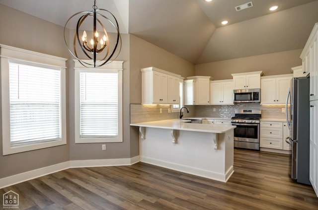 kitchen featuring a sink, a chandelier, stainless steel appliances, a peninsula, and visible vents