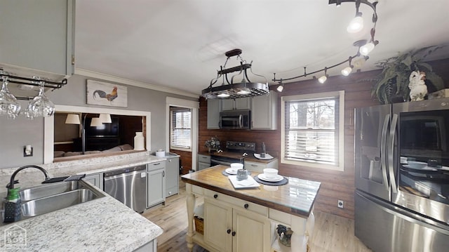 kitchen with ornamental molding, wooden counters, light wood-style floors, appliances with stainless steel finishes, and a sink