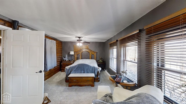 bedroom featuring log walls, ceiling fan, and carpet floors