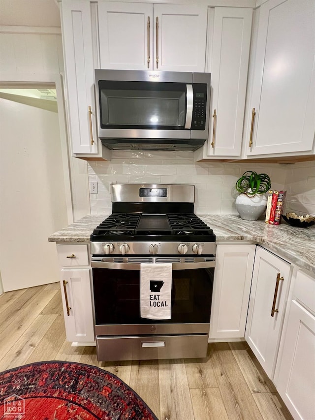 104 N Hunter Ln N, Jonesboro, AR 72405 - kitchen featuring appliances with stainless steel finishes, light wood finished floors, and white cabinetry