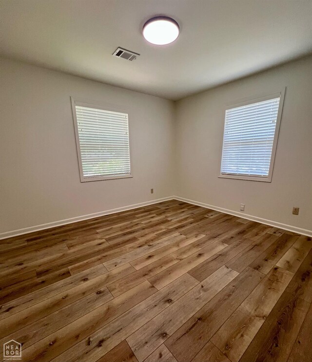104 N Hunter Ln N, Jonesboro, AR 72405 - empty room featuring dark wood finished floors, healthy amount of natural light, and baseboards