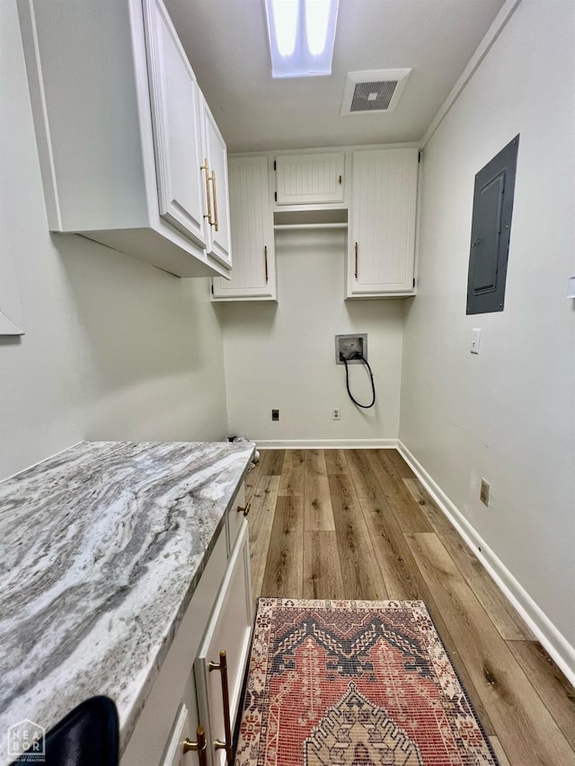 104 N Hunter Ln N, Jonesboro, AR 72405 - washroom featuring electric panel, hookup for a washing machine, light wood-style flooring, cabinet space, and baseboards