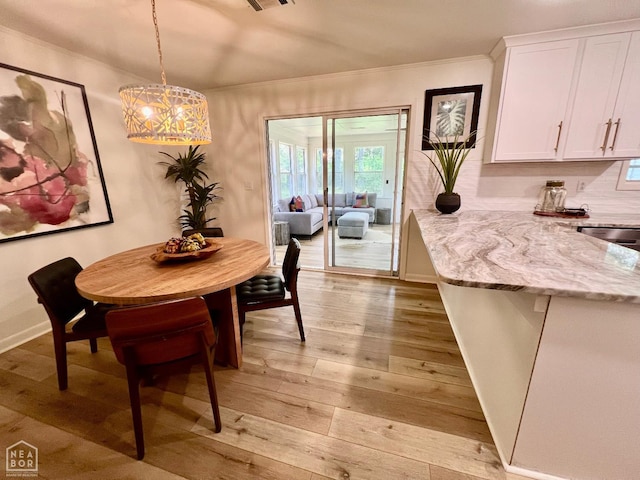 104 N Hunter Ln N, Jonesboro, AR 72405 - dining space with light wood finished floors, a chandelier, ornamental molding, and baseboards