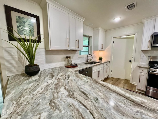 104 N Hunter Ln N, Jonesboro, AR 72405 - kitchen featuring appliances with stainless steel finishes, a sink, light wood-type flooring, light stone countertops, and white cabinets