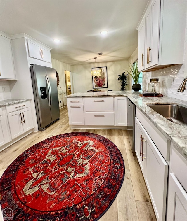 104 N Hunter Ln N, Jonesboro, AR 72405 - kitchen with appliances with stainless steel finishes, a peninsula, a sink, light wood-type flooring, and white cabinets