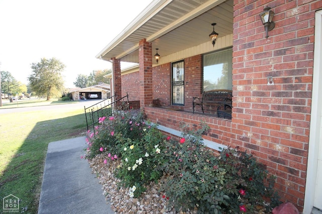exterior space featuring brick siding, a porch, and a yard