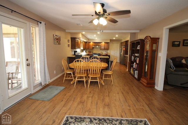 dining room featuring baseboards, a ceiling fan, and light wood finished floors
