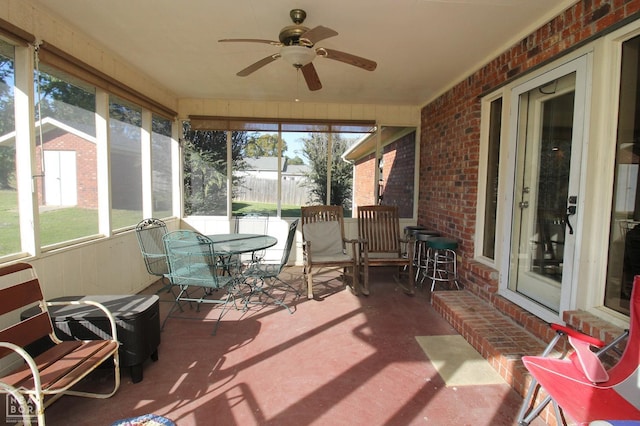 sunroom featuring outdoor dining space and a ceiling fan