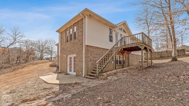 2101 Belleview Cv, Jonesboro, AR 72404 - view of side of home with a deck, fence, stairs, brick siding, and french doors