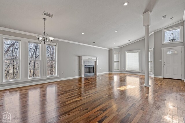 2101 Belleview Cv, Jonesboro, AR 72404 - unfurnished living room with decorative columns, ornamental molding, vaulted ceiling, visible vents, and hardwood / wood-style floors