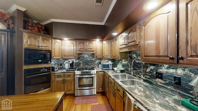 3102 Sara Creek Dr, Jonesboro, AR 72401 - kitchen with black appliances, crown molding, light wood-style floors, decorative backsplash, and brown cabinetry