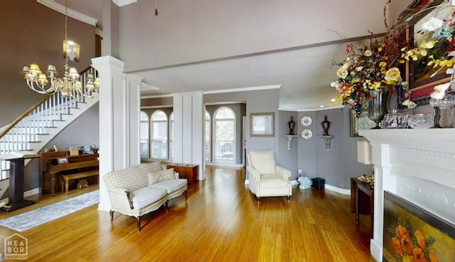 3102 Sara Creek Dr, Jonesboro, AR 72401 - living area with ornamental molding, wood finished floors, stairway, a chandelier, and a fireplace