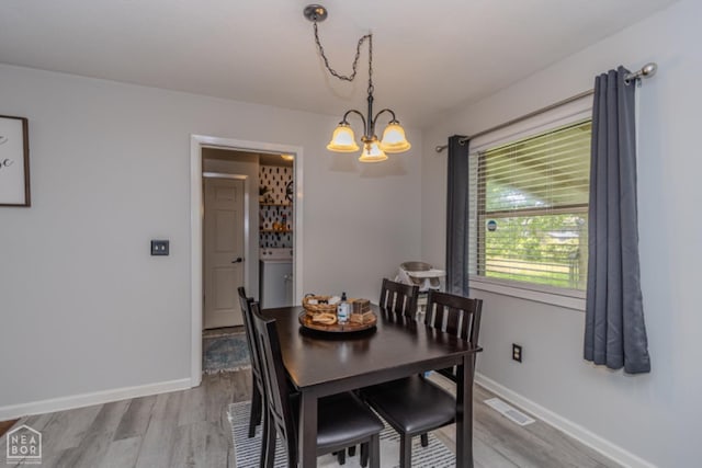 dining area featuring a chandelier, baseboards, visible vents, and light wood-type flooring