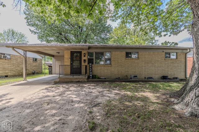 ranch-style home featuring brick siding, driveway, and a carport