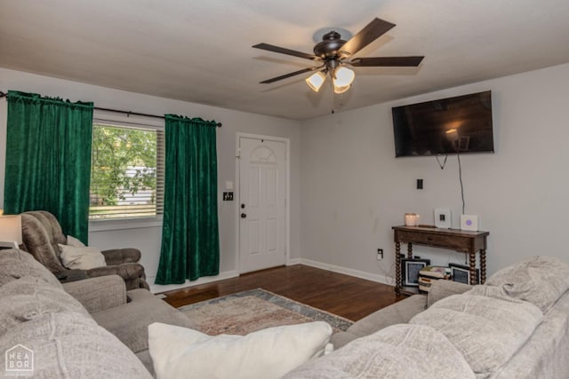 living area featuring a ceiling fan, baseboards, and wood finished floors