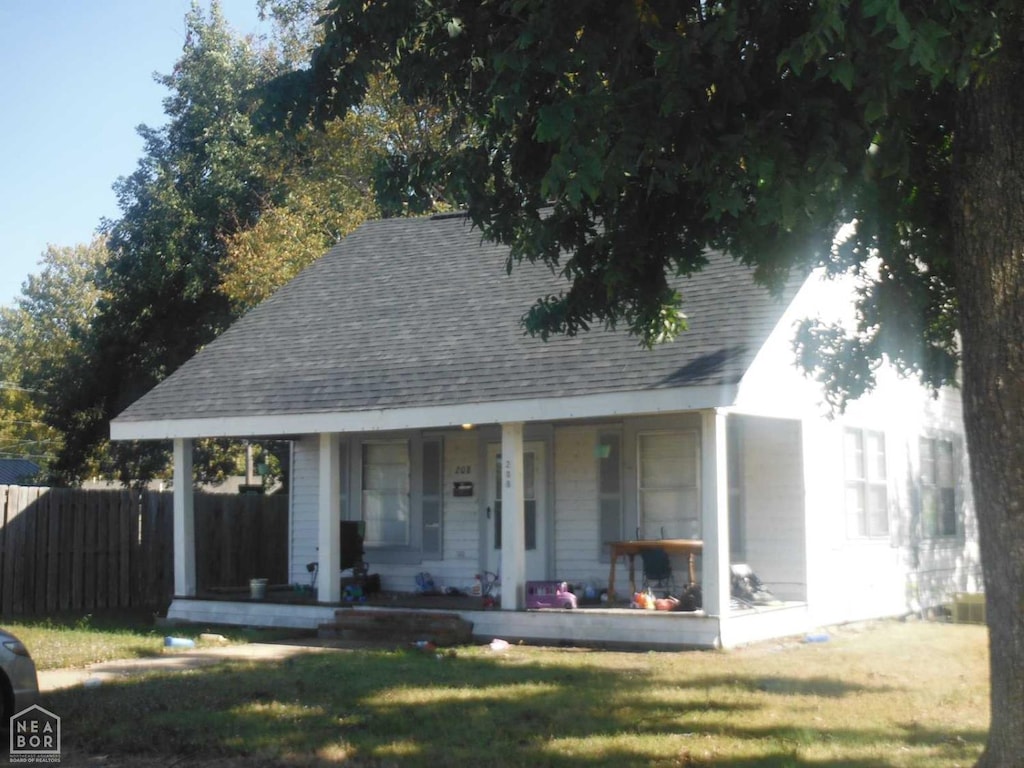 208 NE Front St, Walnut Ridge, AR 72476 - view of front of home with covered porch and a shingled roof