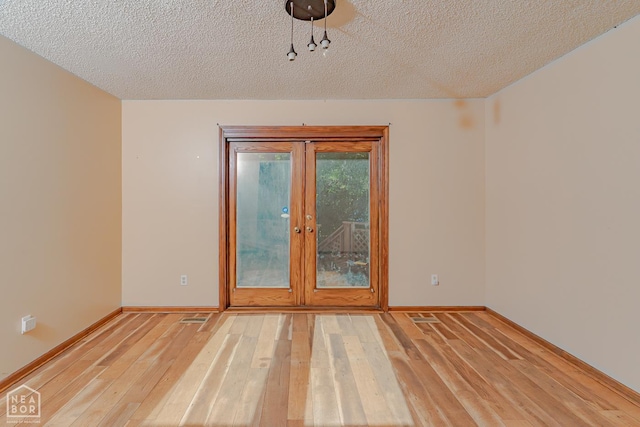 812 Glendale St, Jonesboro, AR 72401 - spare room featuring light wood-type flooring, a textured ceiling, baseboards, and french doors