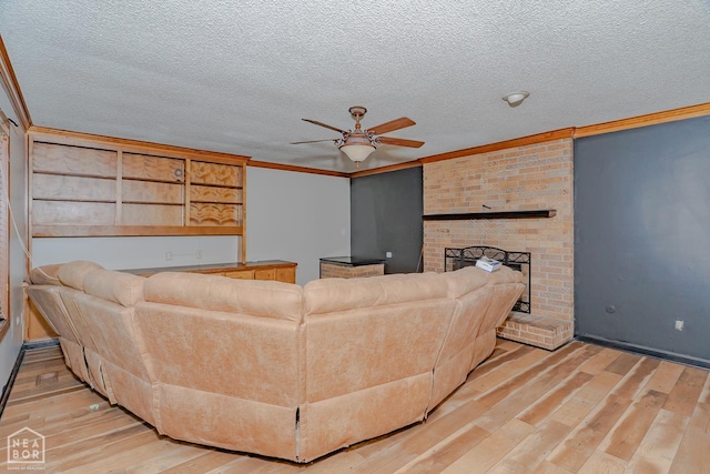 812 Glendale St, Jonesboro, AR 72401 - living room featuring ceiling fan, light wood-style floors, a textured ceiling, crown molding, and a brick fireplace