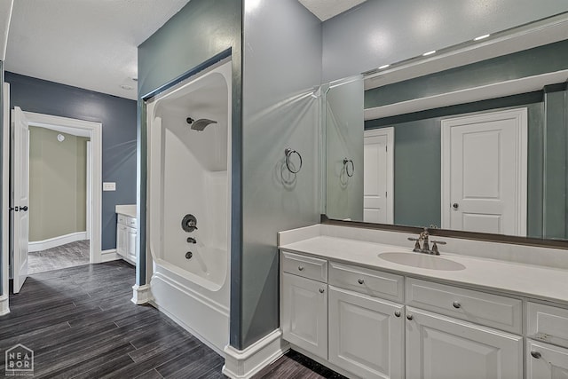 4217 Lochmoor Cir, Jonesboro, AR 72405 - bathroom featuring vanity, washtub / shower combination, wood finished floors, and baseboards