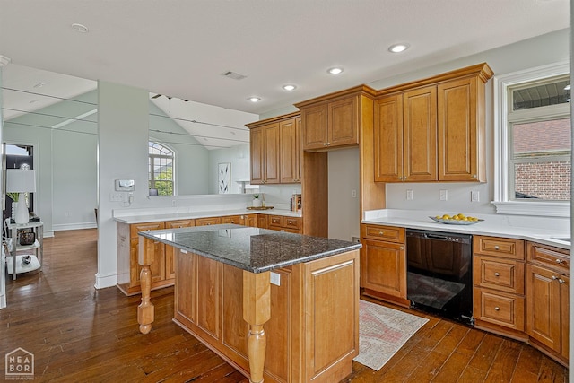4217 Lochmoor Cir, Jonesboro, AR 72405 - kitchen featuring dishwasher, dark wood finished floors, brown cabinetry, a kitchen island, and dark stone countertops