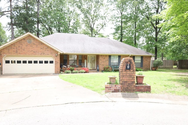 single story home featuring brick siding, a garage, driveway, and a front lawn